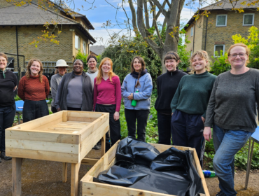 a group of people standing behind newly built raised beds