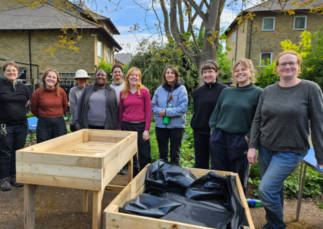 a group of people standing behind newly built raised beds