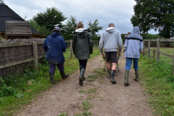 Young people walking and pushing a wheelbarrow on a care farm